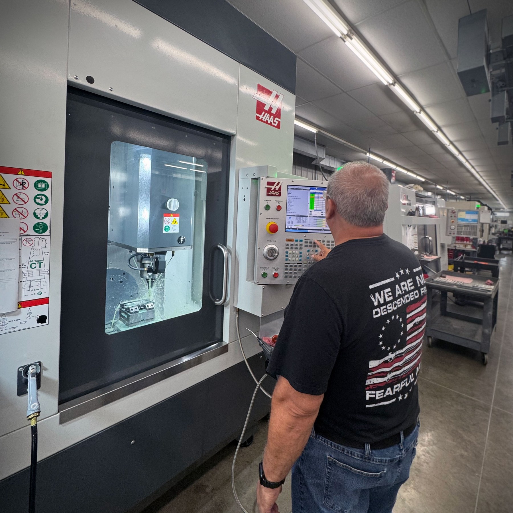 Machinist operating a CNC machining center at Ed Brown Products